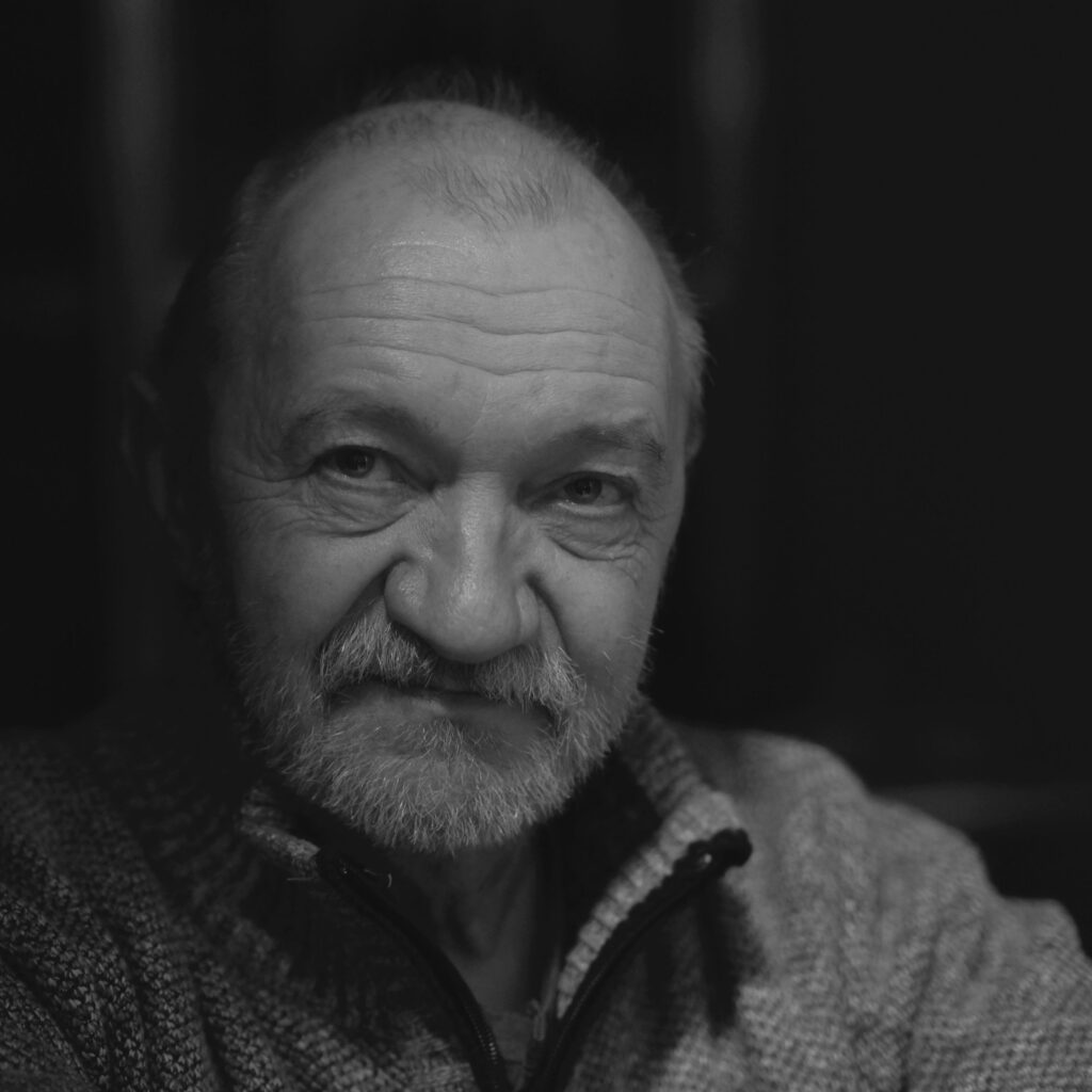 Captivating black and white portrait of an elderly man in a thoughtful pose, highlighting emotions.